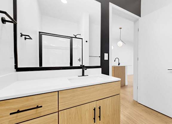 A bathroom with a sink, mirror, and wooden cabinets.