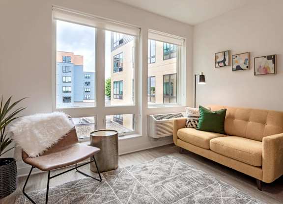 a living room with large windows and a couch and a chair