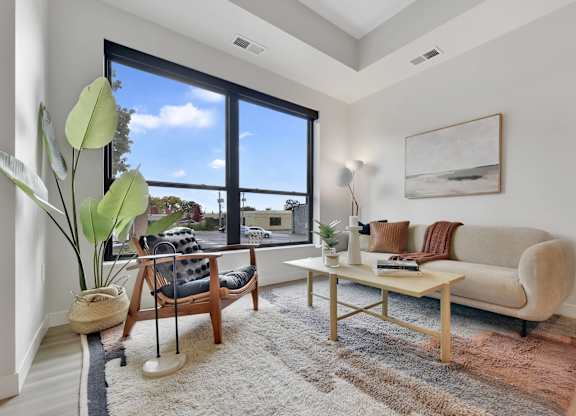 A living room with a couch, chair, and a large window.