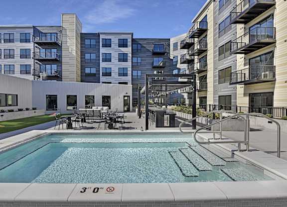 A swimming pool in front of a building with a height restriction sign.