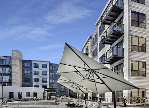 A pool with a metal railing and a white umbrella.