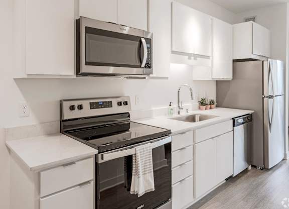 a kitchen with white cabinets and stainless steel appliances and a microwave