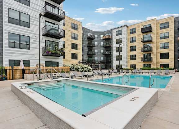 A swimming pool in front of apartment buildings.