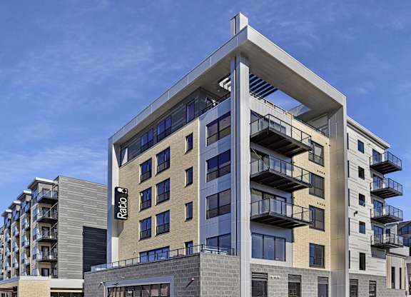 A modern building with a glass facade and balconies.