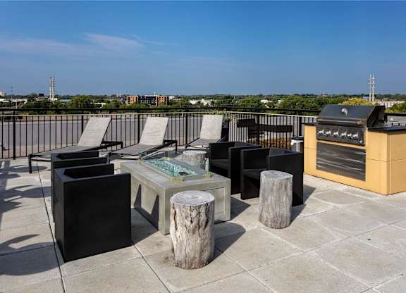 the outdoor patio has a grill and a table with chairs on it