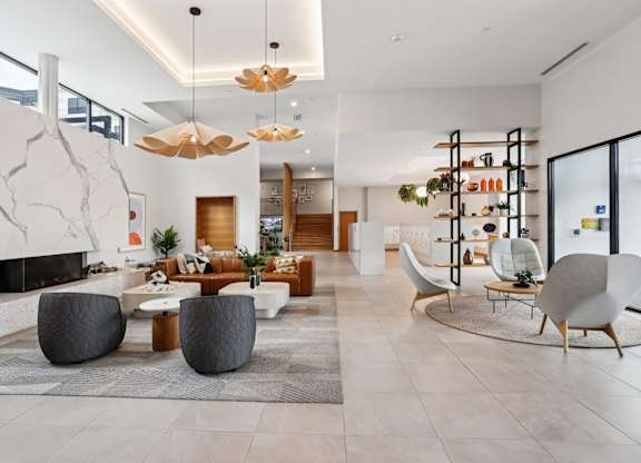 A modern living room with a fireplace and a large rug.