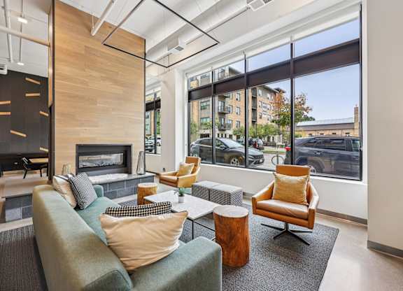 A modern living room with a fireplace and a view of the street outside.