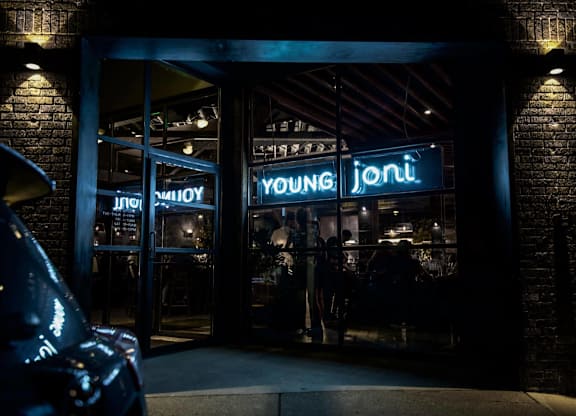 a restaurant at night with a neon sign in the window