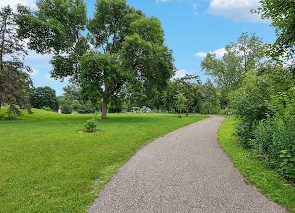 A pathway surrounded by greenery and trees.