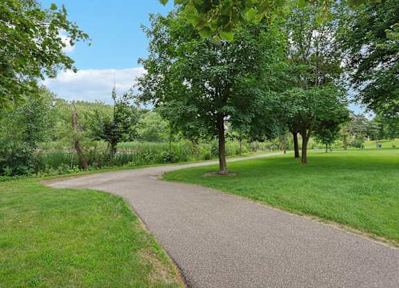 A pathway in a park with trees on both sides.