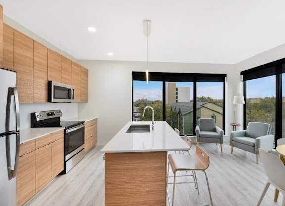 A modern kitchen with a large island and a view of the outdoors.