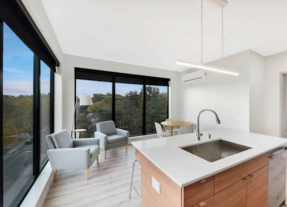 A modern kitchen with a large island and a view of the outdoors.