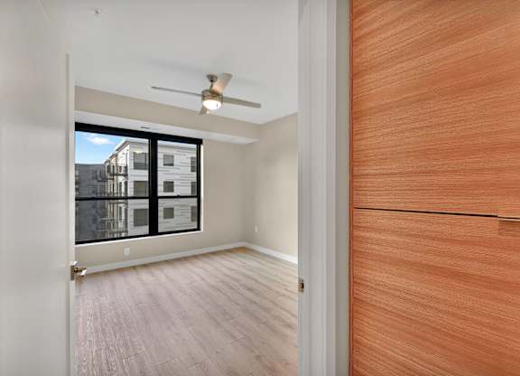 A room with a ceiling fan and a wooden door.