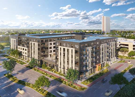 an aerial view of an apartment complex with buildings and a parking lot