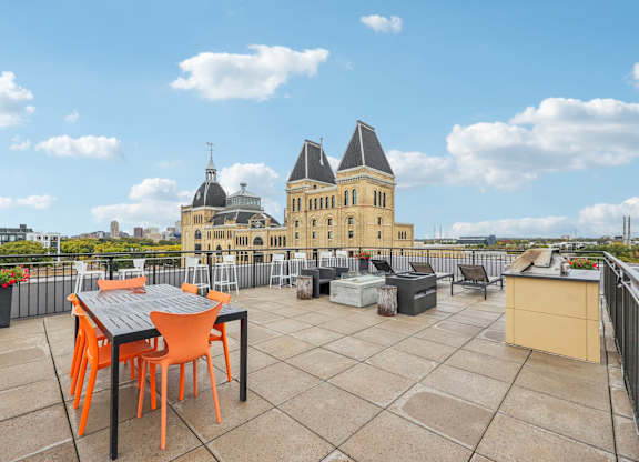 A table and chairs are set up on a rooftop patio.