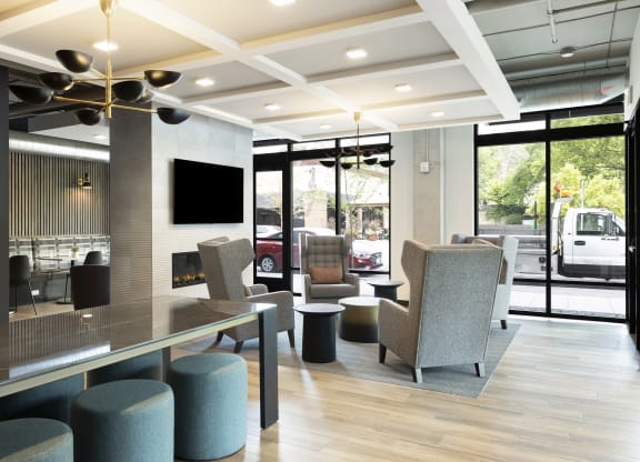 the lobby of a hotel with chairs and a table