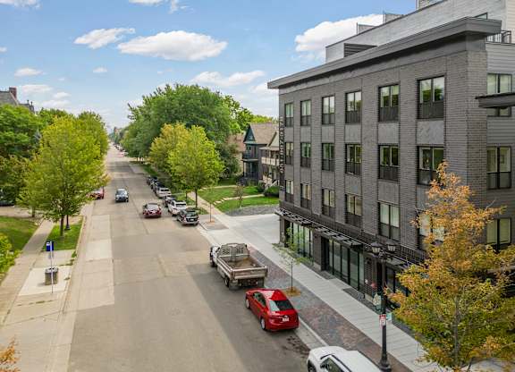 A street with cars and buildings on both sides.