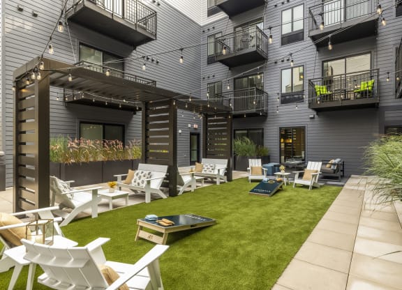 a courtyard with chairs and tables and grass