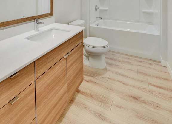 A white toilet sits under a mirror in a bathroom.
