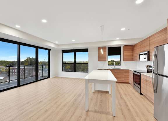 A modern kitchen with a table and chairs in the middle of the room.