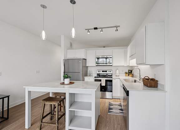 A white kitchen with a table and bar stools.