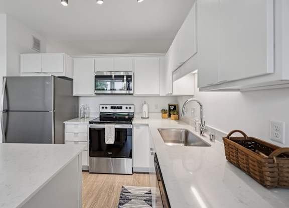 A modern kitchen with a stainless steel refrigerator and a white countertop.