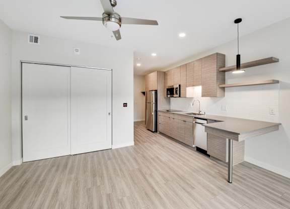 A modern kitchen with a fan on the ceiling.