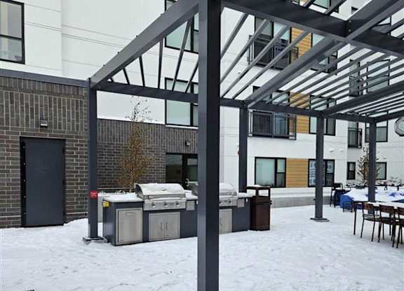 A snow-covered ground with a black metal pole in the foreground.