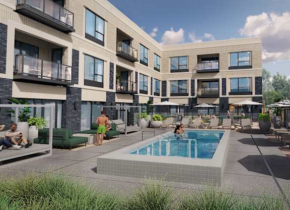 A swimming pool is surrounded by lounge chairs and umbrellas in a courtyard.