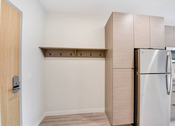 A kitchen with a refrigerator and a door.