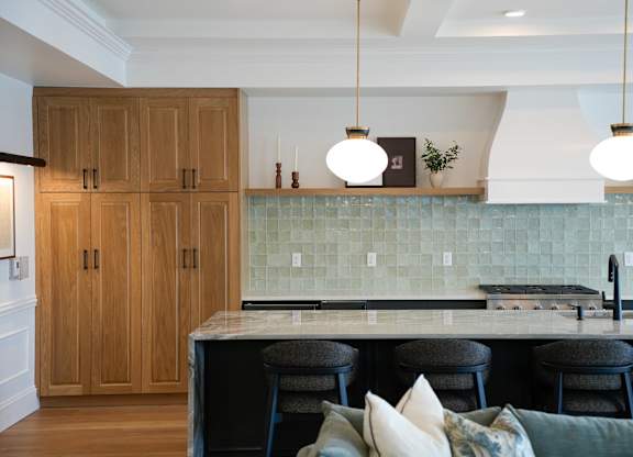 A kitchen with wooden cabinets and a marble countertop.