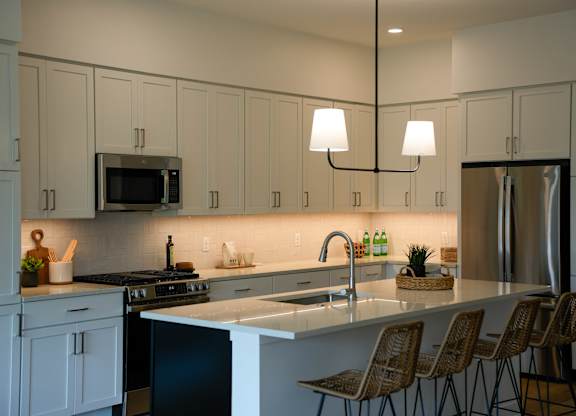 A kitchen with white cabinets and a black stove top oven