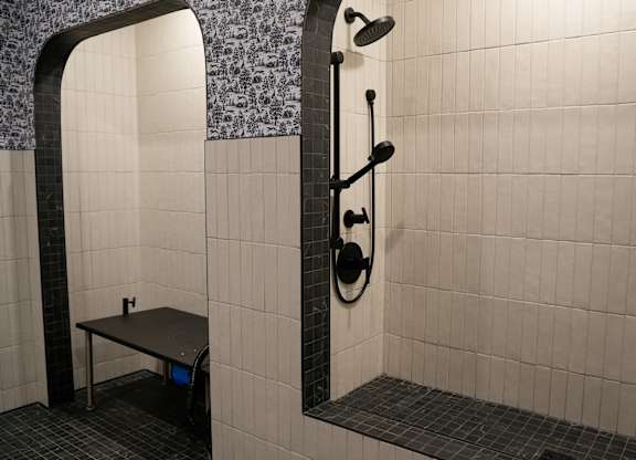 A bathroom with a shower and a bench.