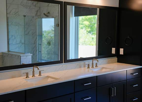 A bathroom with two sinks and a large mirror.