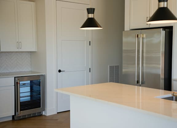 A kitchen with a white counter and a stainless steel refrigerator.