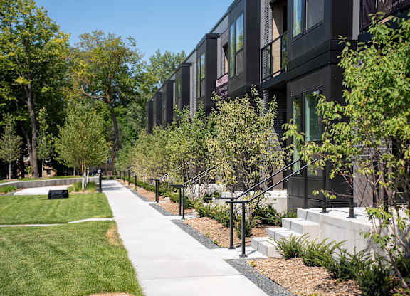 A long black building with a walkway in front of it.
