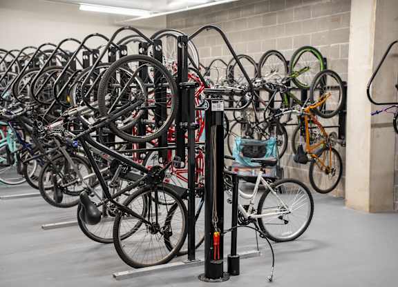 A bike rack full of bicycles in a parking garage.