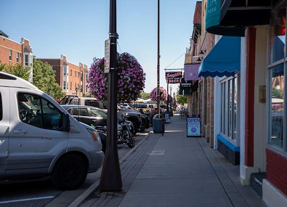 A street view with a white van parked on the side of the road.