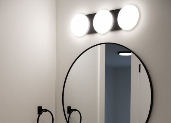 A bathroom with a round mirror and a sink.