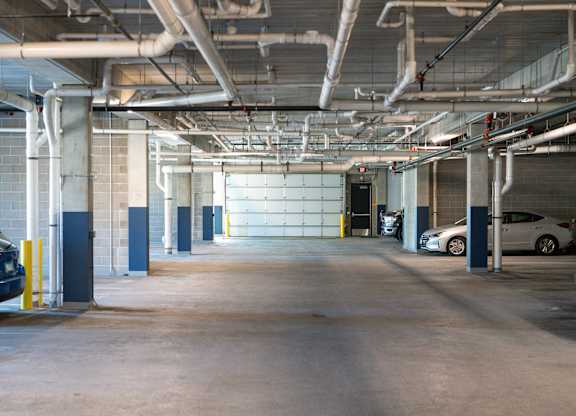 A parking garage with a blue car parked on the left side.