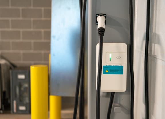 A white charging station with a green light on it.