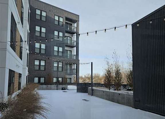 A snow-covered rooftop with a building in the background.