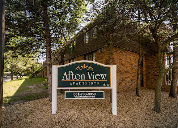 A sign for Alton View Apartment is in front of a brick building.