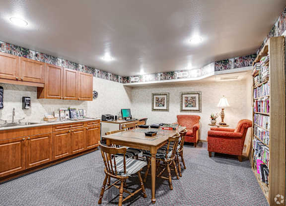 A kitchen with a dining table and chairs.