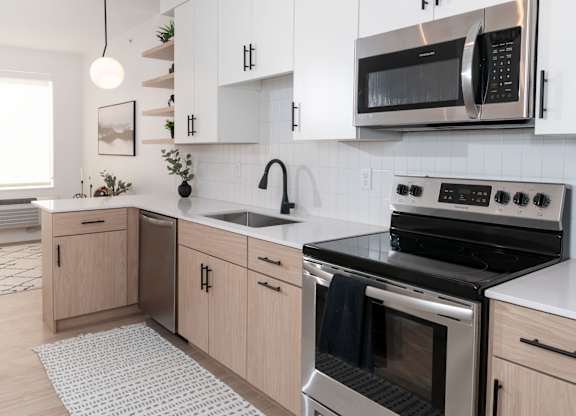 A modern kitchen with a stainless steel oven and microwave.