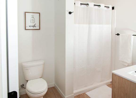 A white toilet sits next to a white sink in a small bathroom.