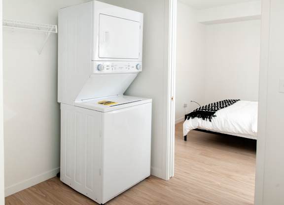A white microwave oven is built into a white cabinet.