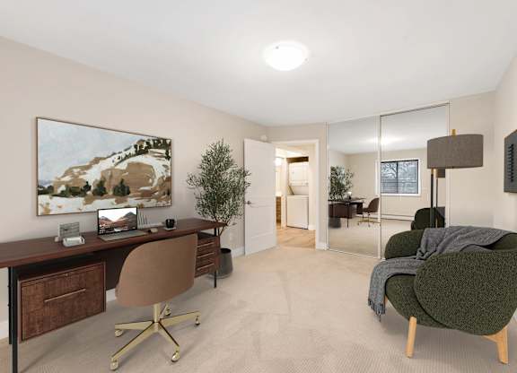 A room with a desk, chair, and a painting on the wall.
