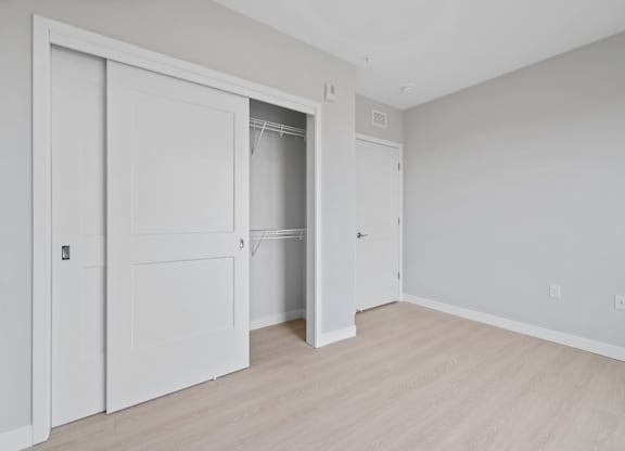 A room with a white wall and brown carpet.