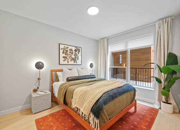 A bedroom with a bed, nightstand, and lamp.